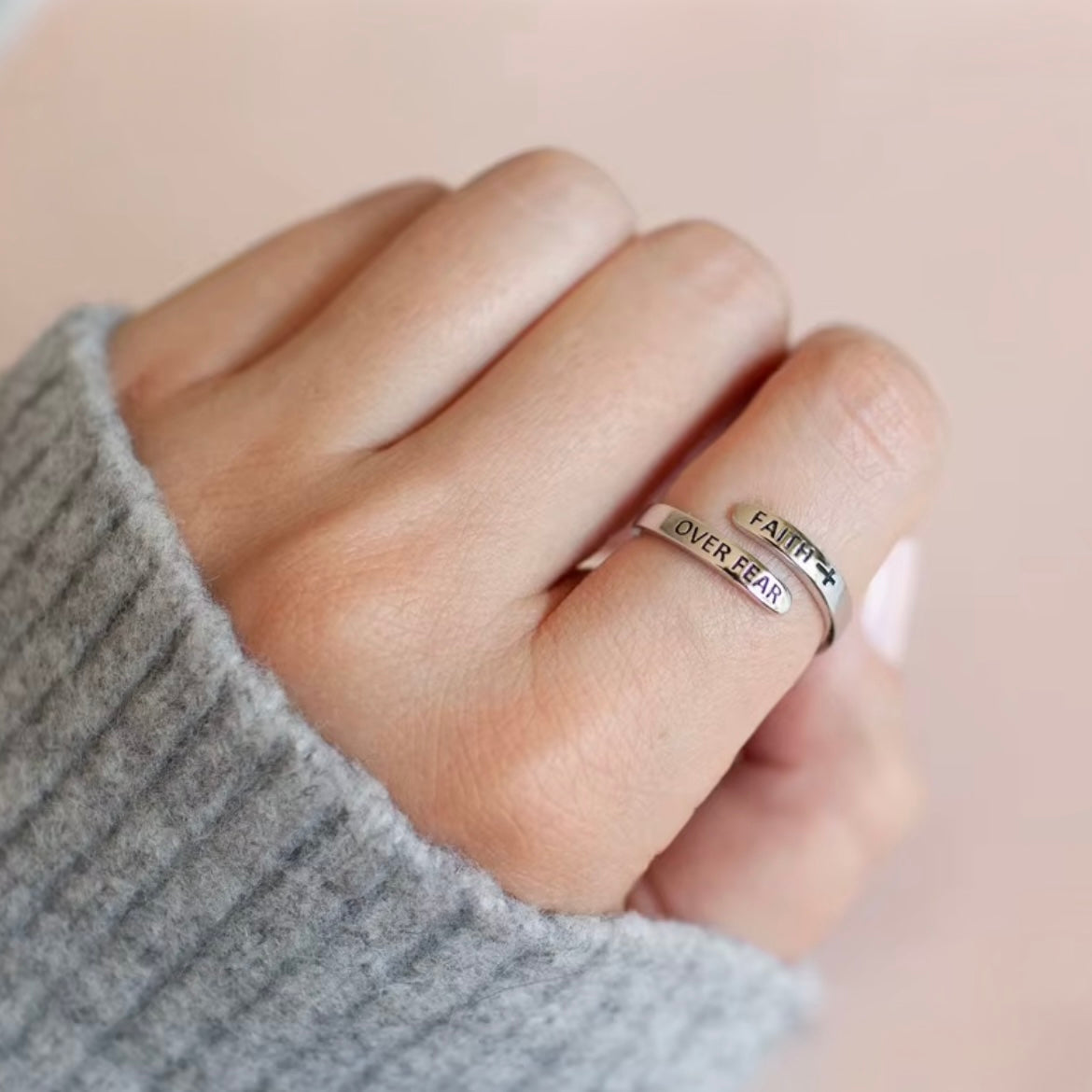 Silver-tone Faith Over Fear ring styled with a gray sweater