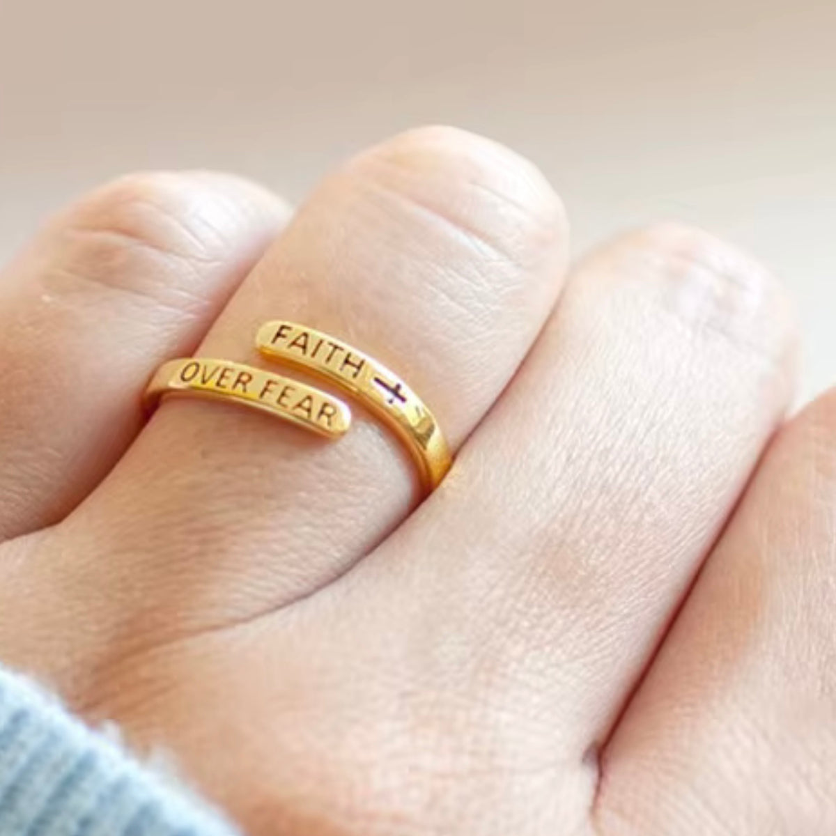 Gold-tone Faith Over Fear ring worn on a hand